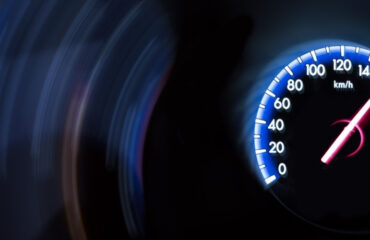 Close-up of a speedometer reading around 170 km/h with motion blur in the background.