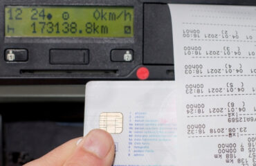 Rol takhohrafiv u dotrymanni norm YeS shcho potribno znaty u 2026 rotsi Close-up of a hand inserting a credit card into a card reader with a receipt printing on the right side of a dashboard device.