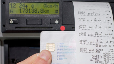 Rol takhohrafiv u dotrymanni norm YeS shcho potribno znaty u 2026 rotsi Close-up of a hand inserting a credit card into a card reader with a receipt printing on the right side of a dashboard device.