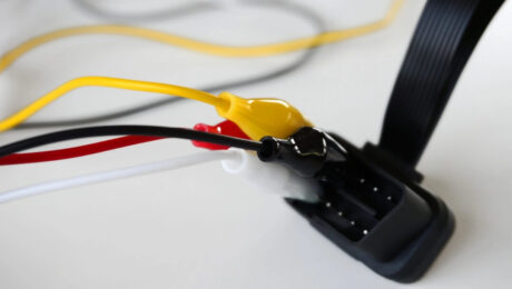 Yak pidklyuchyty takhohraf do CAN-shyny transportnoho zasobu Close-up of a wiring harness with yellow, red, and white wires connected to a black multi-pin connector.