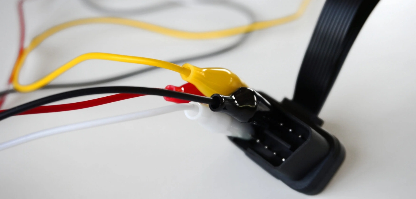 Yak pidklyuchyty takhohraf do CAN-shyny transportnoho zasobu Close-up of a wiring harness with yellow, red, and white wires connected to a black multi-pin connector.